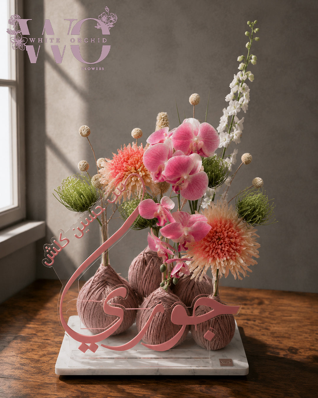 Baby girl newborn flower arrangement with pink orchids, peach chrysanthemums and white flowers