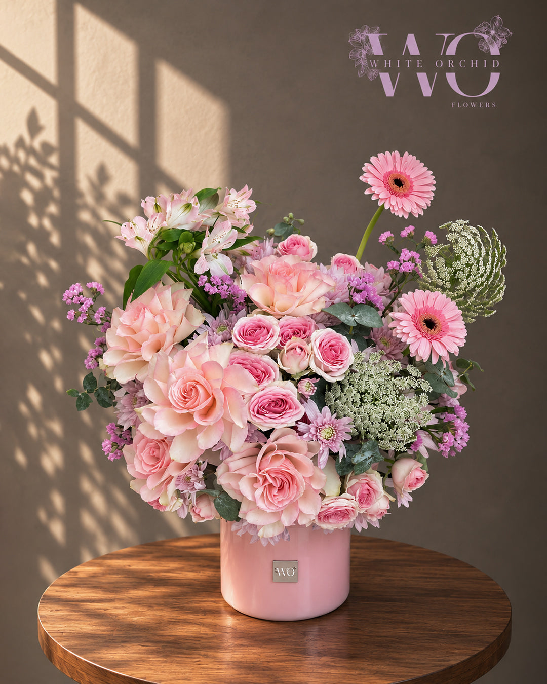 Pink floral arrangement with roses, gerbera daisies and seasonal flowers in a premium pink flower box by White Orchid Flower