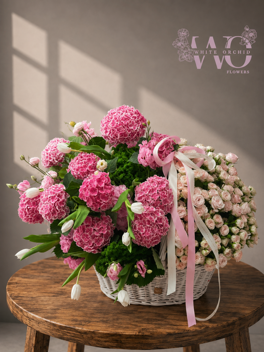 Luxury pink hydrangea and blush rose flower basket with white tulips and green foliage