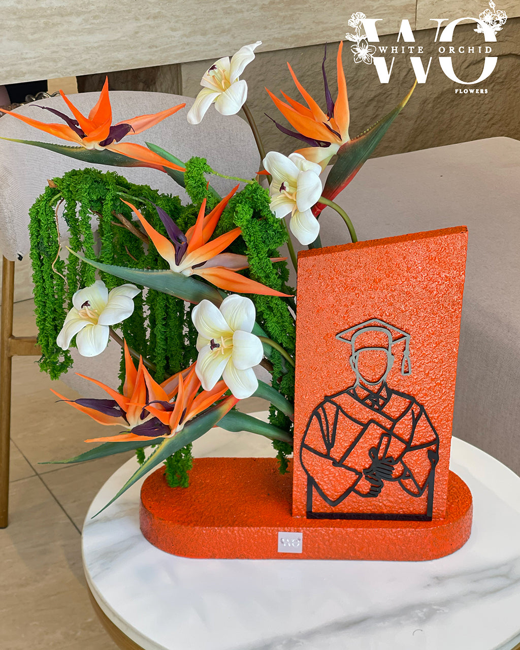Graduation flower arrangement with tropical flowers and graduation design.