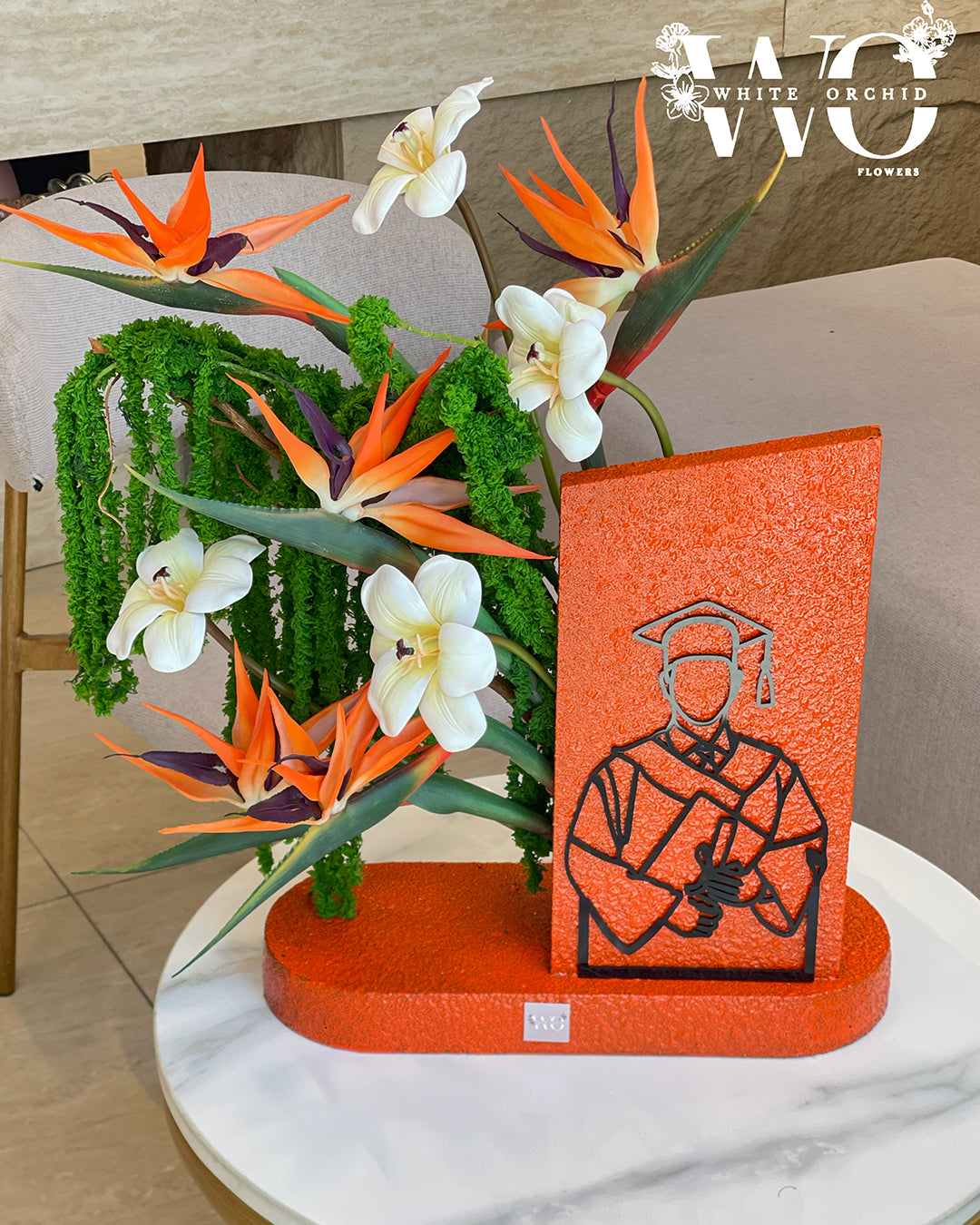 Graduation flower arrangement with tropical flowers and graduation design.