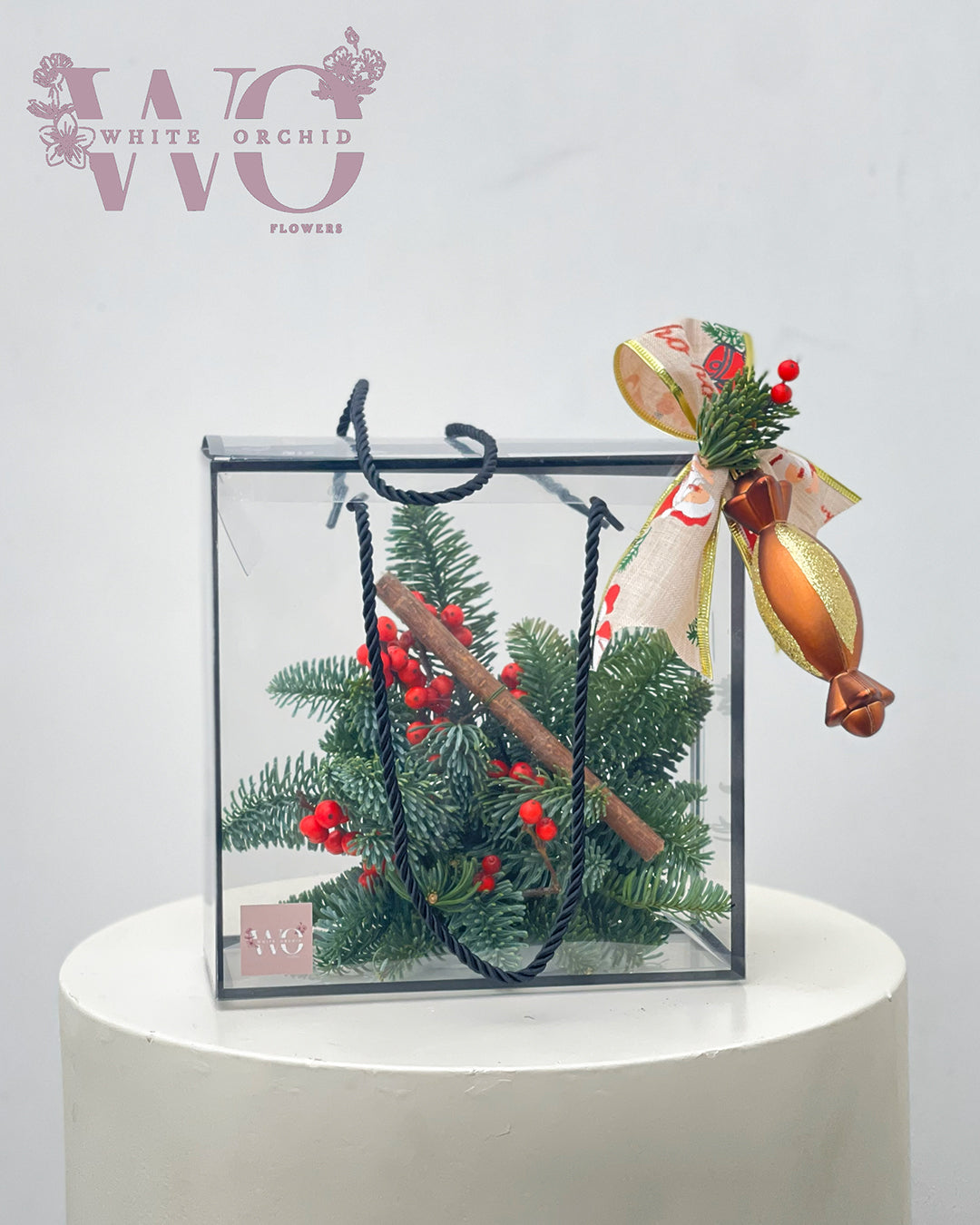 Christmas acrylic box arrangement with winter greenery and festive decorations by White Orchid Flowers – elegant seasonal décor with delivery across all UAE.