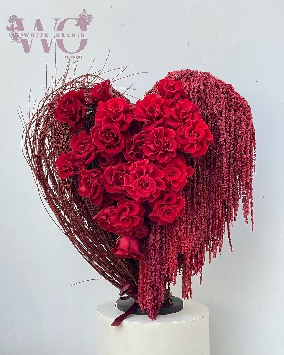 Valentine red heart-shaped flower bouquet made with natural fresh roses by White Orchid Flowers with delivery across all UAE.
