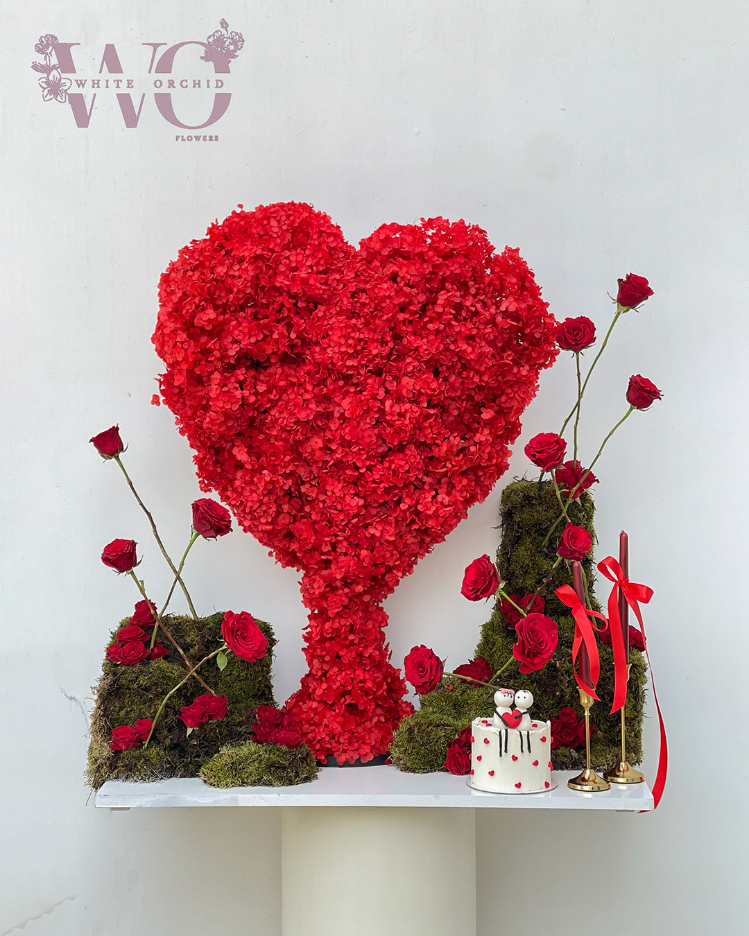 Valentine red rose heart base with cake by White Orchid Flowers – romantic flower and cake gift with delivery across all UAE.
