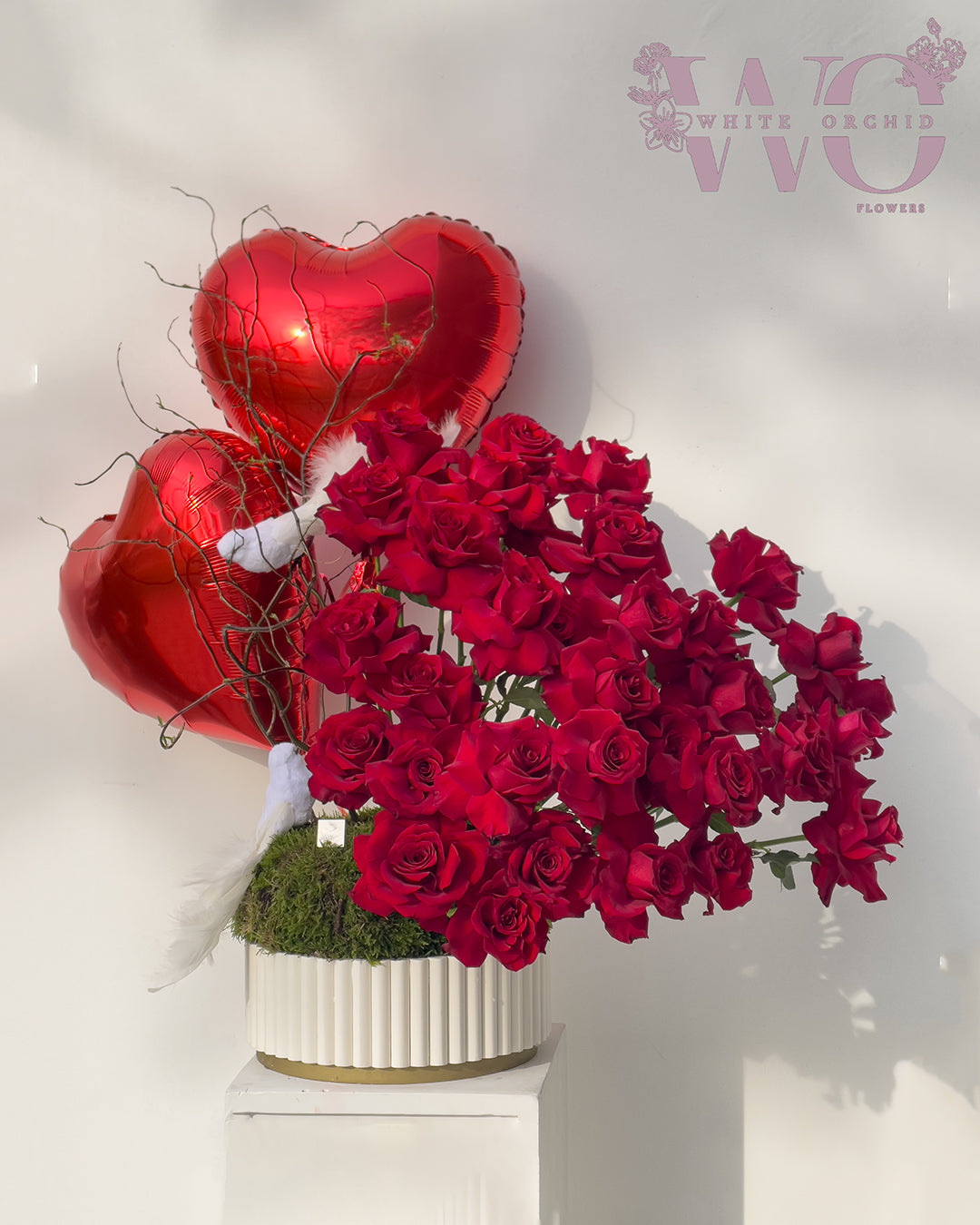 Red rose vase arrangement with heart-shaped helium balloon by White Orchid Flowers – romantic floral gift with delivery across all UAE.