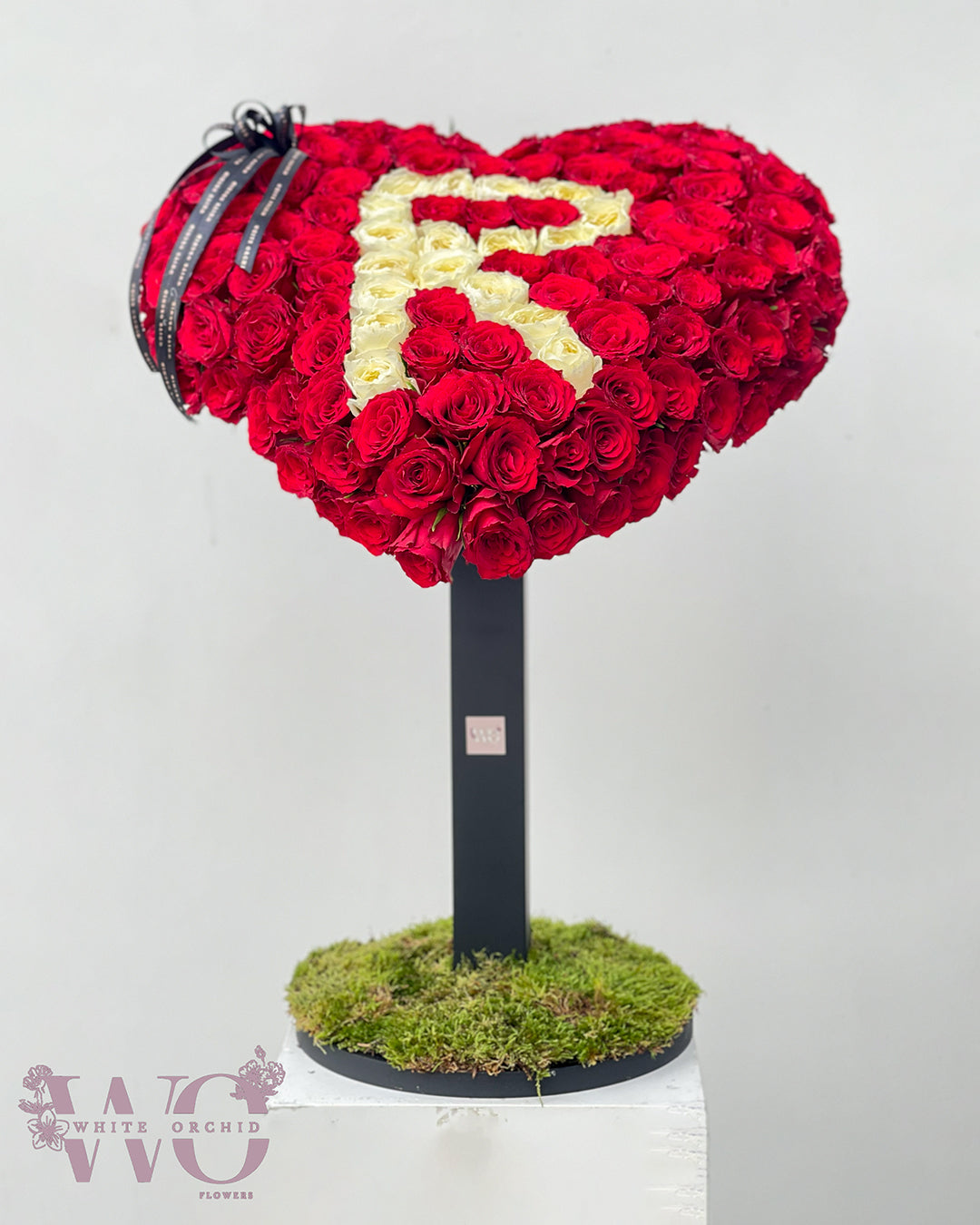 Heart-shaped flower bouquet with custom letter made from natural fresh flowers by White Orchid Flowers – personalized floral design with delivery across all UAE.