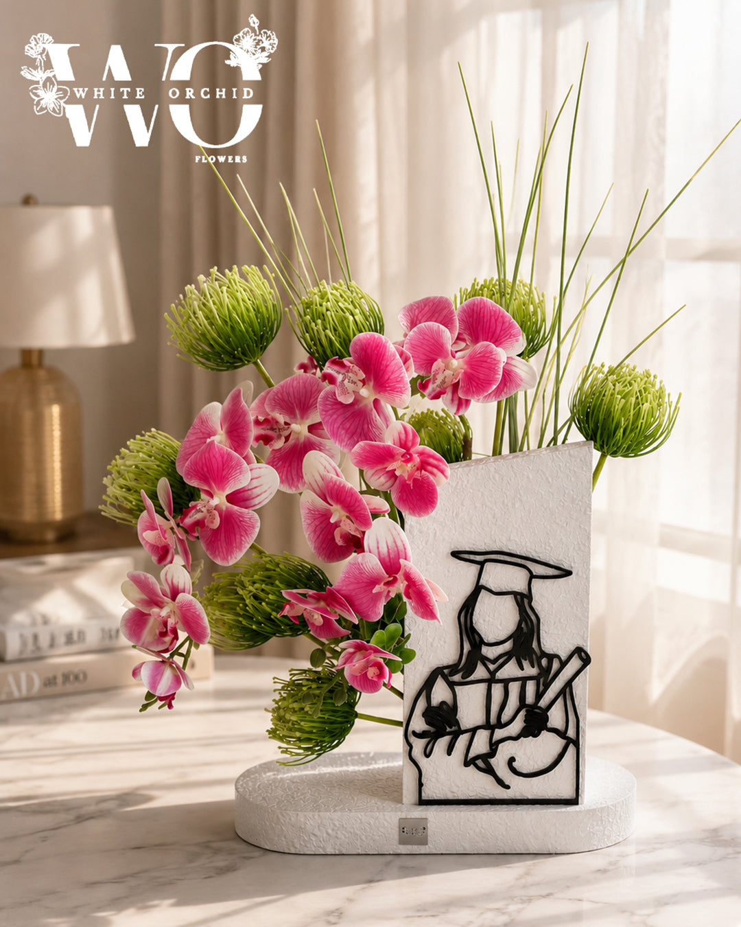 Luxury graduation orchid arrangement with pink flowers and graduation design.