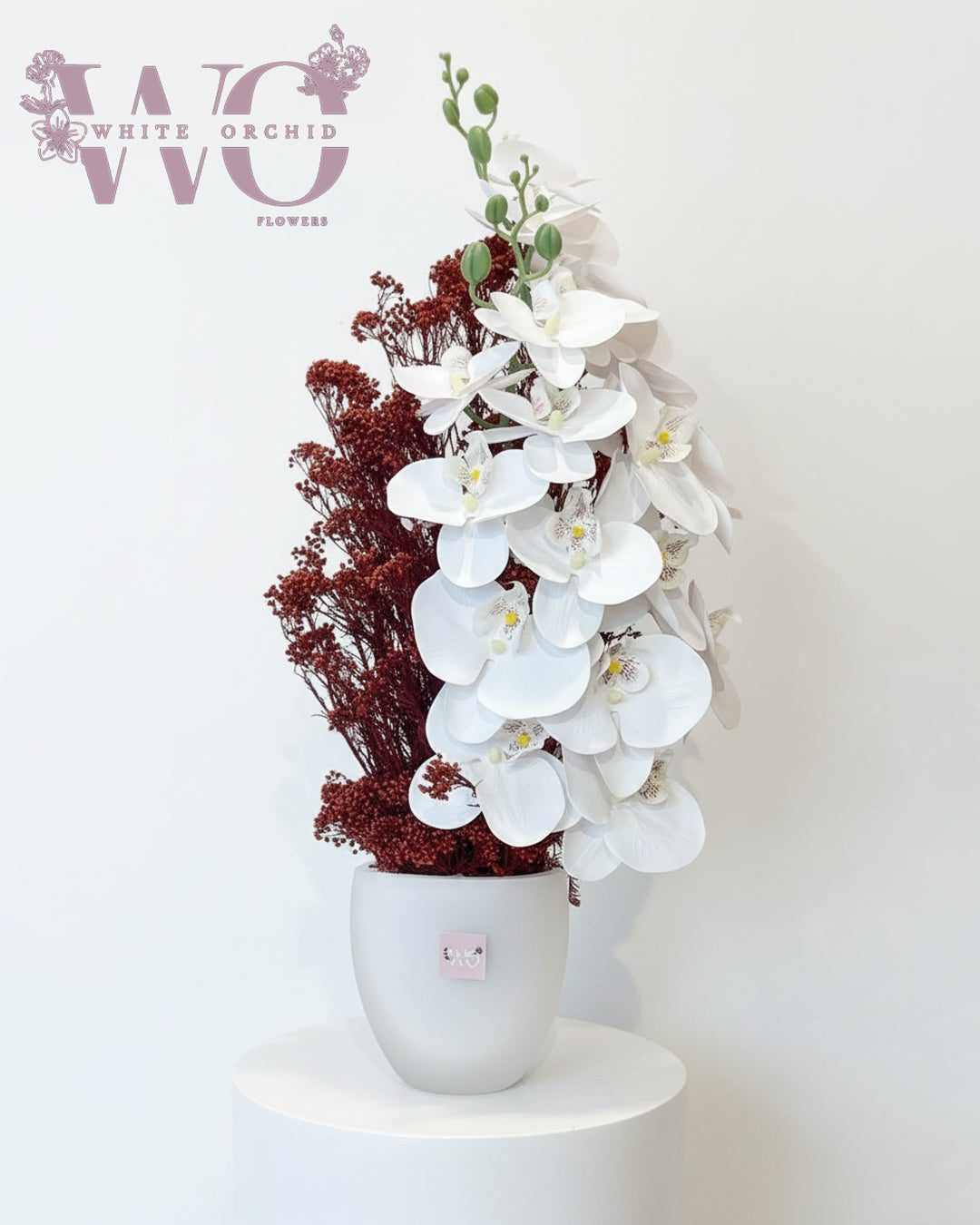 Artificial orchid flower arrangement with white orchids in decorative vase by White Orchid Flowers UAE.