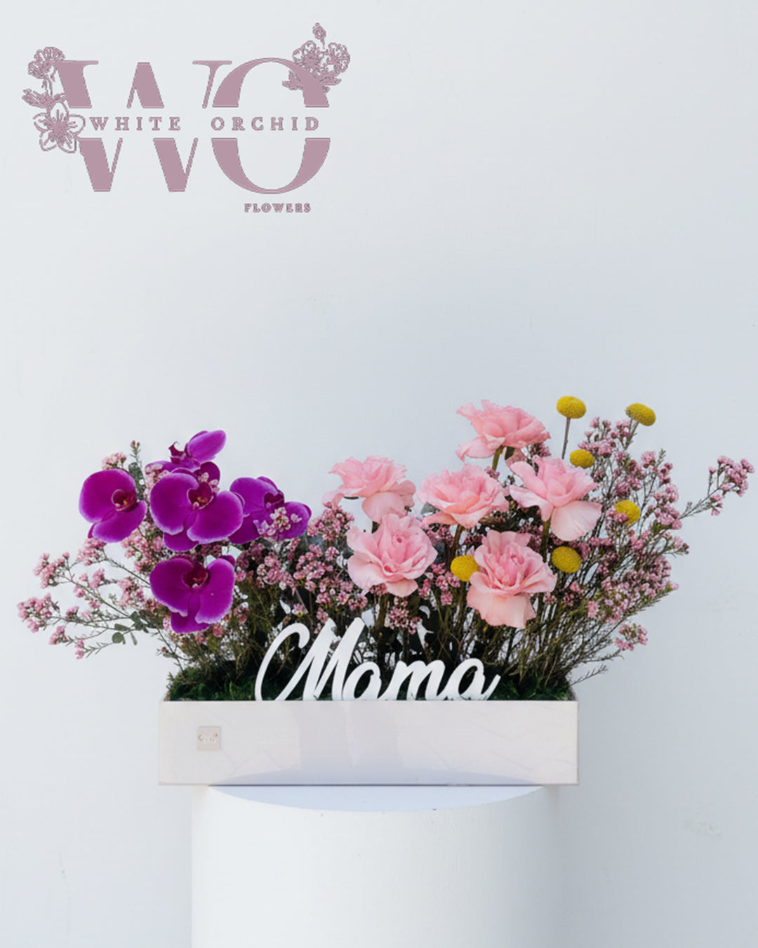 Mother’s Day flower arrangement with orchids and pink flowers and “Mama” detail by White Orchid Flowers UAE.